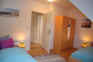 une chambre avec deux lits et une porte avec des lumières dans l'établissement Ferienhaus De lüttje Mööv, à Dorum Neufeld
