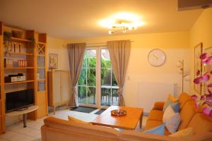 un salon avec un canapé et une télévision dans l'établissement Ferienhaus De lüttje Mööv, à Dorum Neufeld