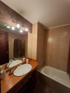 a bathroom with two sinks and a bath tub and a mirror at Padornelo Sur in San Carlos de Bariloche