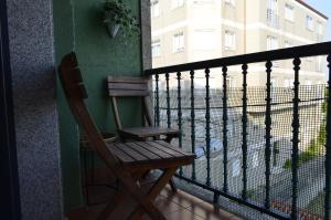 a wooden chair sitting on top of a balcony at Tu Refugio Azul en la Playa -Vilanova de Arousa in Villanueva de Arosa