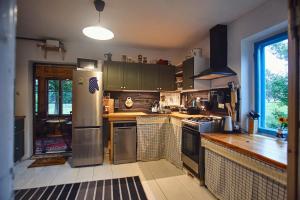 a kitchen with a refrigerator and a stove top oven at Dębinówka in WilczÄ™ta
