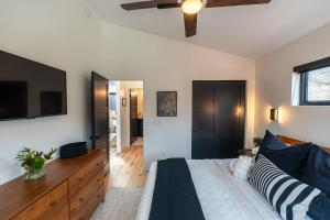 a bedroom with a bed and a tv on the wall at Michigan Mod Walk To Downtown in Saugatuck