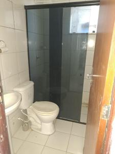 a bathroom with a toilet and a glass shower at Apto aconchegante Belém in Belém