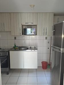 a white kitchen with a sink and a refrigerator at Apto aconchegante Belém in Belém