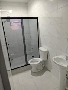 a white bathroom with a toilet and a sink at Apto aconchegante Belém in Belém