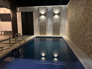 a swimming pool with lights on a brick wall at Casa Adriana in Río Dulce