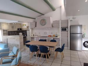 une cuisine avec une table en bois et des chaises bleues dans l'établissement Les toits d'Eyguières, à Eyguières