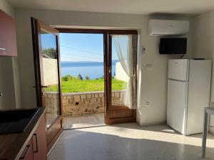 a kitchen with a refrigerator and a view of the ocean at Studio Apartment Ravel in Ičići