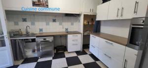 a kitchen with white cabinets and a checkered floor at Chambre 2 - avec grande terrasse in Port-la-Nouvelle