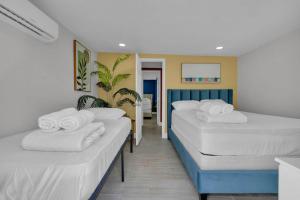 two beds in a room with white towels on them at La Pergola Villa 7 Br Poolhot Tub Location in Miami +35 photos