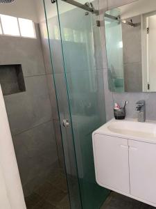 a shower with a glass door next to a sink at Casa GALLARDO in Manzanillo +17 photos