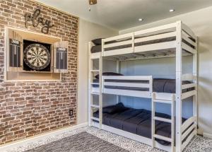 een kamer met stapelbedden en een dartbord aan een bakstenen muur bij Absolutely Gorgeous, Modern Retreat W Hot Tub in Sevierville