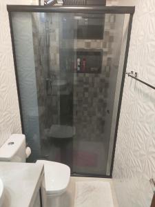 a bathroom with a shower and a white toilet at Apartamento Cantinho da Cop 30 in Ananindeua
