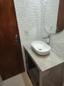 a bathroom with a white sink on a counter at Apartamento Cantinho da Cop 30 in Ananindeua +2 photos