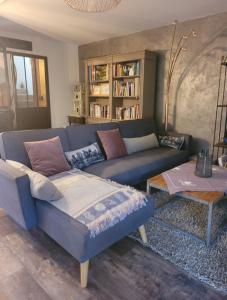 a living room with a blue couch and a table at Maison de vacances à l'Ayguade classée 3 étoiles, climatisée,3mn à pied plage et restos ,5mn aéroport, 10mn gare in Hyères