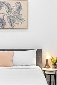 a bedroom with a bed with a picture on the wall at Cozy Double Room in Kensington - Walk to UNSW Easy CBD Access -External and Shared Kitchen or Bathroom Access in Sydney