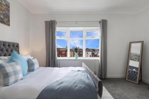 レッドカーにあるThe Skippers Rest Coastal Homeのベッドと大きな窓のある寝室