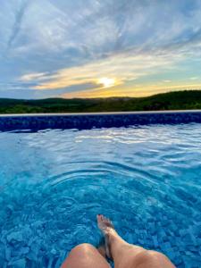 a person laying in the water in a swimming pool at Cipó Chalés in Jaboticatubas