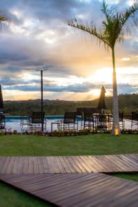 a table and chairs and a palm tree and the ocean at Cipó Chalés in Jaboticatubas +32 photos