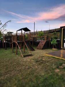 a playground with a slide and a swing set at Cipó Chalés in Jaboticatubas
