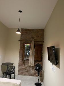 a living room with a brick fireplace and a television at Hotel Villa Nature Br 153 in Hidrolândia