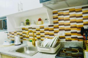 a kitchen counter with a sink and a sink at Mesavirre Garden Residences - Skybox Living in Bacolod