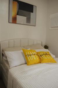 two yellow pillows sitting on top of a bed at Mesavirre Garden Residences - Skybox Living in Bacolod +43 photos