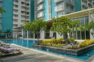 a swimming pool with trees and a building at Mesavirre Garden Residences - Skybox Living in Bacolod