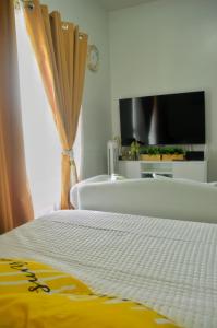 a bedroom with a bed and a tv and a window at Mesavirre Garden Residences - Skybox Living in Bacolod