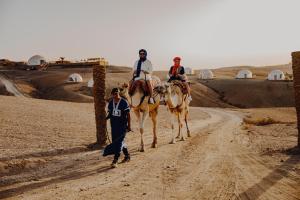 three people riding on horses on a dirt road at The Orion Dome in El Karia