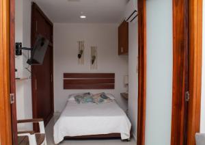 ein kleines Schlafzimmer mit einem Bett und einem Fernseher in der Unterkunft Encantador Apartamento El Laguito Bocagrande in Cartagena de Indias