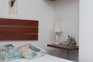 ein Bett mit einem hölzernen Kopfteil und ein Tisch mit einer Lampe in der Unterkunft Encantador Apartamento El Laguito Bocagrande in Cartagena de Indias + 17 Fotos