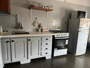 a kitchen with a stove and a refrigerator at Complejo Semaso in Santa Rosa