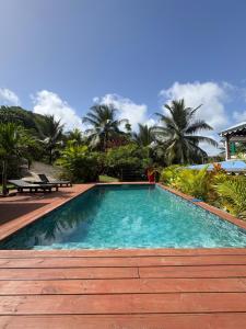 a swimming pool in a resort with palm trees at Villa Mamalouken App Manea in Quartier Préfontaine