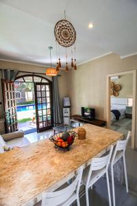 a kitchen with a table with a bowl of fruit on it at Apartamento Charmoso com Piscina Ampla e Natureza in Aracati