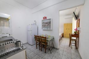 a kitchen with a table and a white refrigerator at Apartment's Theodoros in Kamena Vourla