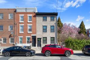フィラデルフィアにあるWelcome to The Lux Collective a Spacious 5-Bedroom House close to Stadiums, Universities, Center City & more!のレンガ造りの建物の前に停められた車両2台