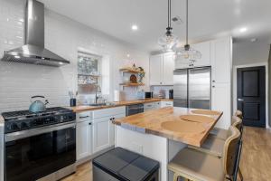 フィラデルフィアにあるWelcome to The Lux Collective a Spacious 5-Bedroom House close to Stadiums, Universities, Center City & more!の白いキャビネットと木製のカウンタートップを備えたキッチン
