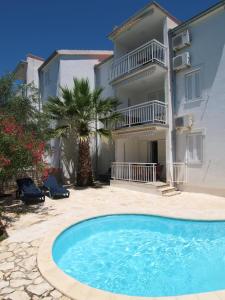 a house with a swimming pool in front of a building at Olea Apartments in Srima