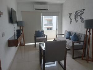 a living room with a couch and a chair at Precioso depa a 70 mts de playa in Manzanillo