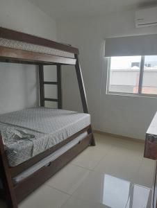 a bedroom with a bunk bed and a window at Precioso depa a 70 mts de playa in Manzanillo