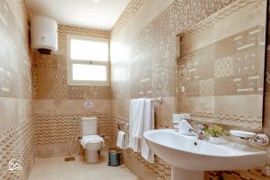 een badkamer met een wastafel en een toilet bij Pyramids Oasis Hotel in Caïro +51 foto's