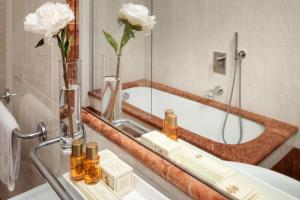 y baño con bañera y lavabo con espejo. en Hotel Executive, en Florencia