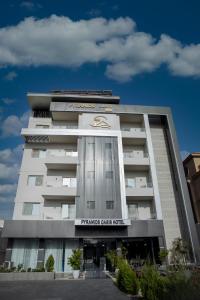 een groot wit gebouw met een hotel van de Namsan-groep bij Pyramids Oasis Hotel in Caïro