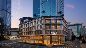 a building in a city with tall buildings at voco Chengdu Chunxi Road by IHG in Chengdu