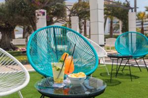 a table with a drink and a bowl of chips at Cala Millor Garden Hotel - Adults Only in Cala Millor