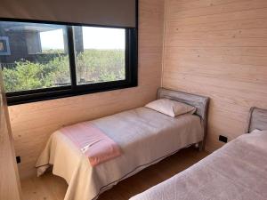 a small room with a bed and a window at Sunset House - Endemic-Punta de Lobos in Chacurra