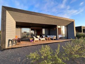 a house with a large deck with furniture on it at Sunset House - Endemic-Punta de Lobos in Chacurra