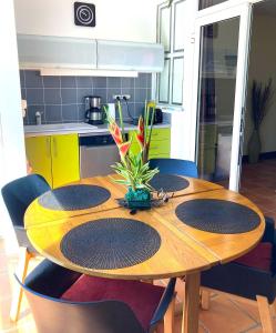 a kitchen with a wooden table with chairs around it at Karpé diem in Saint-François