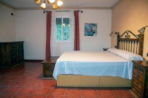 een slaapkamer met een bed, een ladekast en een raam bij Casa rural Cavila in Pliego